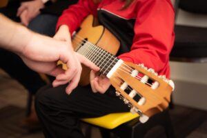 About Dino - Image 1 a young boy getting guitar lessons