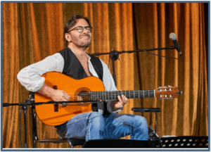Improve Guitar Playing-Image of Al Di Meola playing live with acoustic guitar