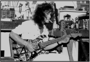 7 Ways To- Upgrade An Electric Guitar-Image of EVH playing his Red Franken Strat in his work shop