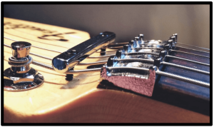 7 Ways To- Upgrade An Electric Guitar-Image of a nut saddle at the headstock