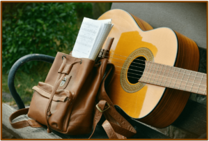 Martin Steel String Backpacker Acoustic Guitar-Image of guitar and a backpack on a outside bench