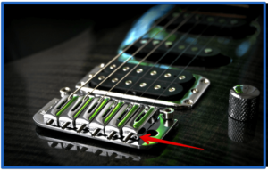buzz feiten tuning system review-image of a bridge on a electric guitar with chrome adjustable saddles