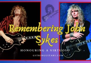 john sykes- The Feature image of the artist live on stage with his black guitar and standing with his black guitar