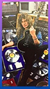 John Sykes-image of Sykes at his home studio with his guitar and platium albums